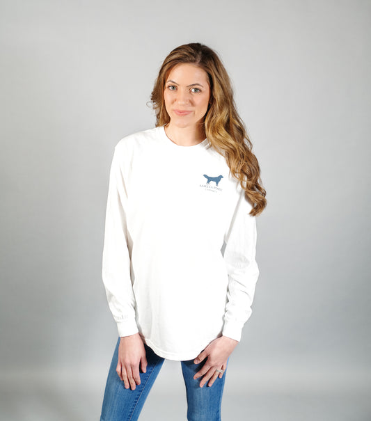 Image of the front side of the shirt on a female person, shirt pocket sized golden retriever logo in true navy color on a white color long sleeve shirt, Amelia Point Clothing Co is underneath the retriever logo